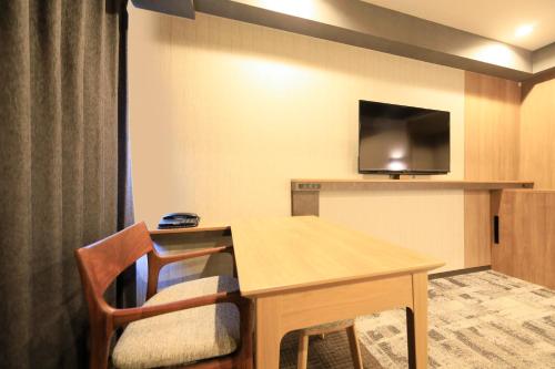 成田成田Richmond酒店的客房设有桌子和平面电视。