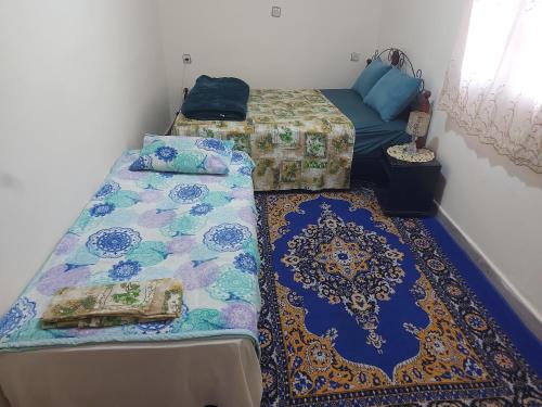 阿加迪尔Chambre chez l'habitant avec famille的一间客房配有两张床、一张沙发和地毯。