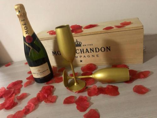 San SilvestroAtena B&B APARTMENTS Gold的一瓶葡萄酒、香槟盒和红花