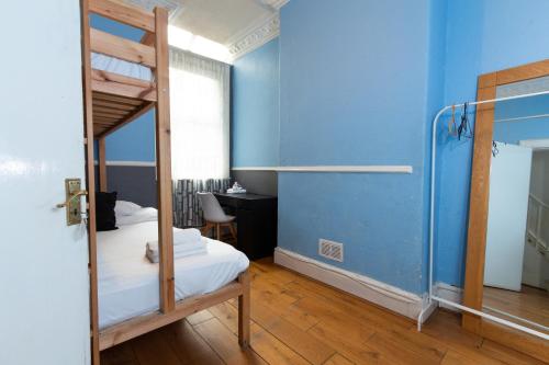 曼彻斯特Suite 1 - Cosy Room Close to MCR City Centre的一间卧室设有一张双层床和蓝色的墙壁。
