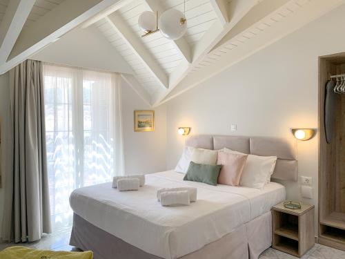 阿尔戈斯托利翁Rouchotas Apartments的卧室设有一张白色大床和天花板