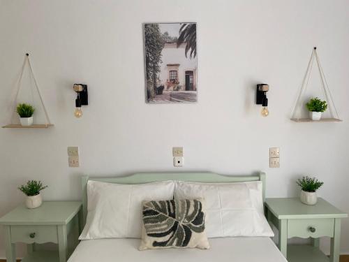 帕蒂迪里奥Ξενοδοχειο Julietta的卧室配有一张带两张桌子的床,墙上挂着一张照片