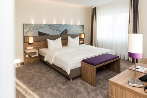 勒讷斯特拉特曼斯酒店的酒店客房设有一张大床和一张书桌。