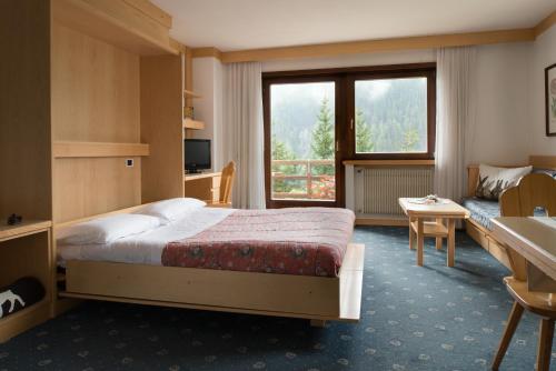 圣克里斯蒂娜Apartments Boè的酒店客房设有一张床和一个大窗户