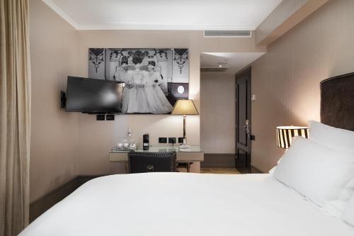 特拉维夫北德凯Ｂ酒店的酒店客房,设有一张床,墙上挂着一身连衣裙