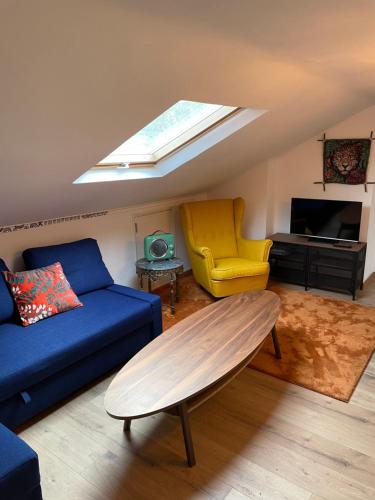卡斯卡伊斯Lisbon Soul Surf Camp的客厅配有蓝色的沙发和黄色的椅子