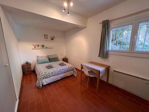弗雷瑞斯SIMONE, Appartement maison, quartier calme, grande terrasse, SPA, barbecue, 2 chambres的一间卧室配有一张床、一张书桌和一个窗户。