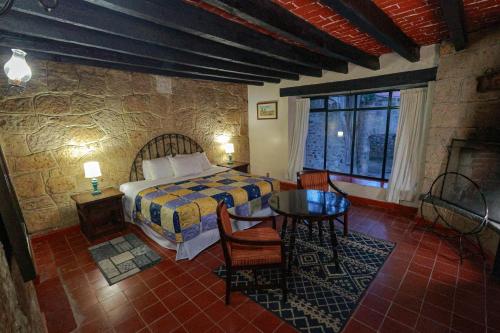 瓦斯卡坎波Hotel Hacienda San Miguel Regla的卧室配有一张床和一张桌子