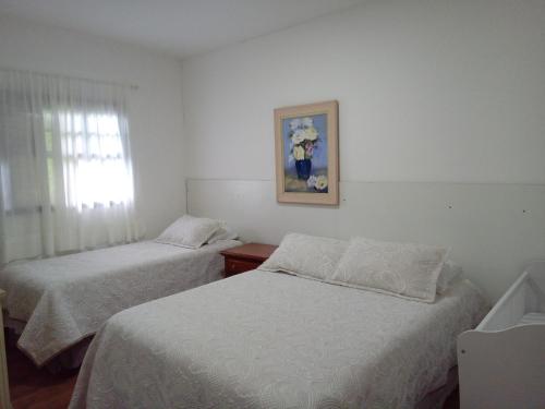 坎波斯杜若尔当Casa dos Neves的一间卧室设有两张床和一扇带照片的窗户。