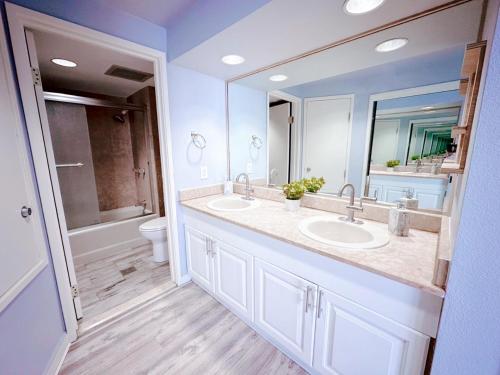 塔穆宁Alupang Beach Tower, UPGRADED units的浴室设有2个水槽、卫生间和镜子。