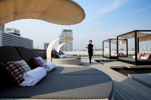 曼谷Centara Watergate Pavilion Hotel Bangkok的站在建筑物屋顶上的女人