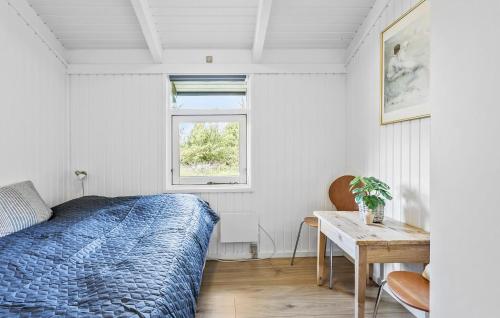 斯特兰比Gorgeous Home In Strandby With Kitchen的一间卧室配有一张床、一张桌子和一个窗户。