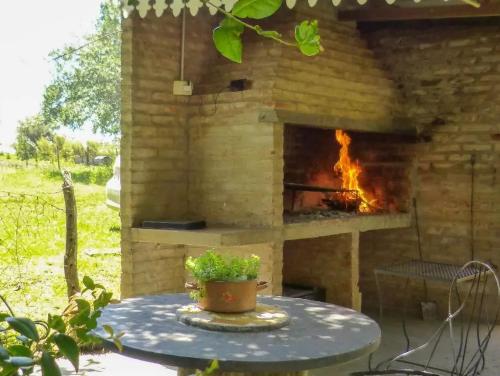 埃利萨镇Solar de Campo的庭院内的石头壁炉,配有桌子