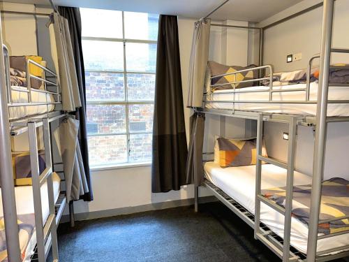 墨尔本墨尔本欧洲旅舍的宿舍间设有双层床和窗户。