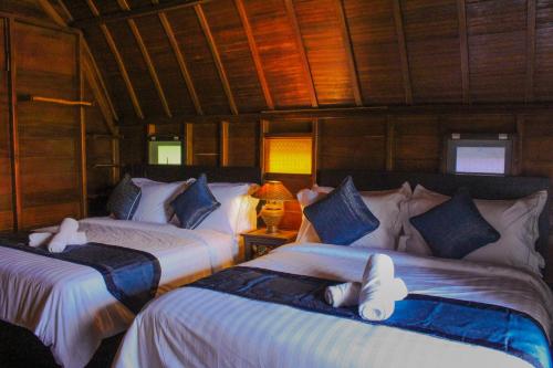珍南海滩Golden Chenang Village的木墙客房的两张床