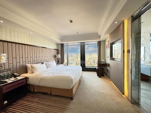 南京南京苏宁环球套房饭店的一间卧室设有一张大床和一个大窗户
