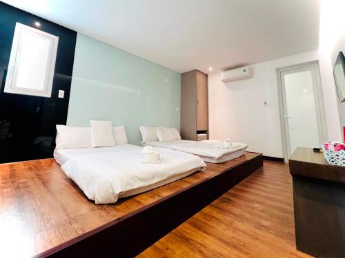 岘港Holiday Inn Hotel的一间卧室配有两张带白色床单的床