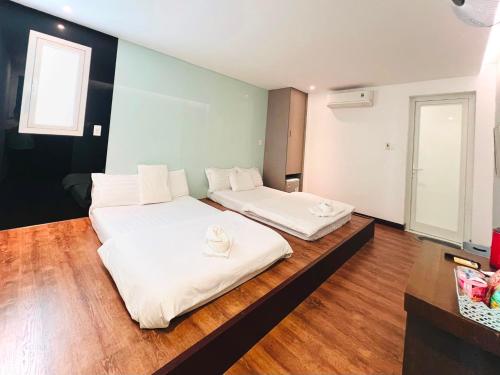 岘港Holiday Inn Hotel的铺有木地板的客房内的两张床