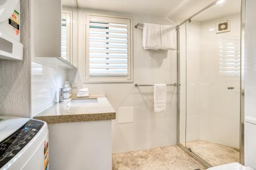 努萨角海风度假酒店的带淋浴和盥洗盆的白色浴室