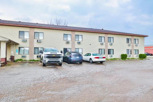 PipestoneOYO Hotel Pipestone MN, Canterbury Park的两辆汽车停在大楼前的停车场