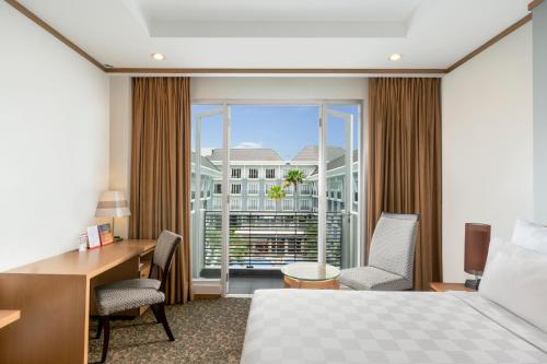 帕朗卡拉亚瑞士贝尔达奴姆帕朗卡拉亚酒店的配有一张床、一张书桌和一扇窗户的酒店客房