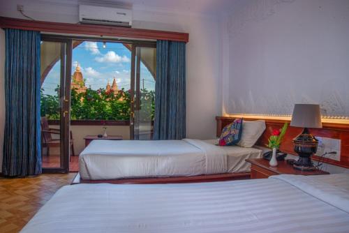 蒲甘Myanmar Nan Hteik Temple View Hotel的酒店客房设有两张床和大窗户。