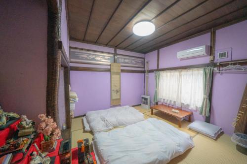 小樽小樽民泊太田1号館的卧室设有紫色墙壁、一张床和一张桌子
