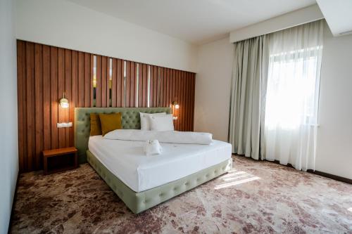 克拉约瓦Hotel Relax Craiova的卧室设有一张白色大床和一扇窗户。