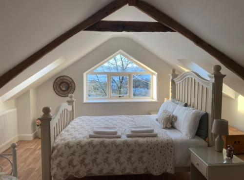 LlanwrdaPippin Lodge的卧室配有白色的床和窗户