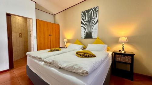 斯瓦科普蒙德Bushbabies-Inn Self-Catering Accommodation的一间卧室配有两张带黄色枕头的床。