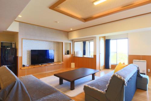 热海Mujuan的客厅配有沙发和桌子