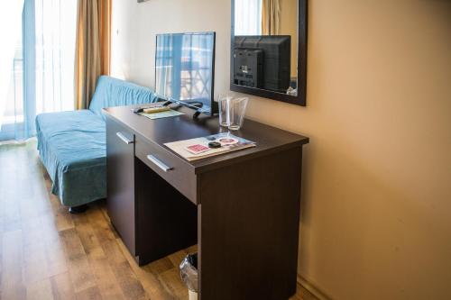 普里莫尔斯科布纳维斯塔酒店的客房设有一张桌子、一台电视和一张沙发。