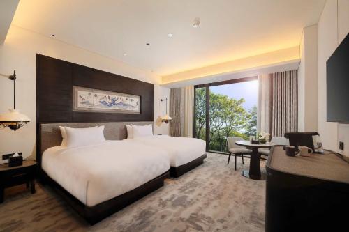 三宝垄Padma Hotel Semarang的酒店客房设有一张大床和一张书桌。