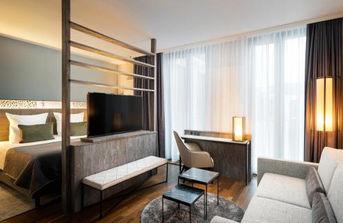慕尼黑慕尼黑里奥纳多皇家酒店的一间酒店客房,配有一张床和一台电视