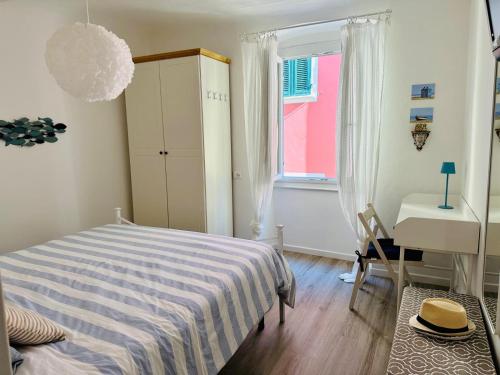 莱里奇l'altro Cuore di Lerici的一间卧室配有一张床、一张书桌和一个窗户。
