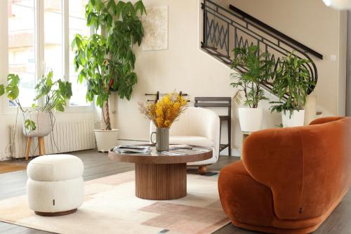 滨海圣奥班Le Clos Normand的客厅设有植物和桌椅