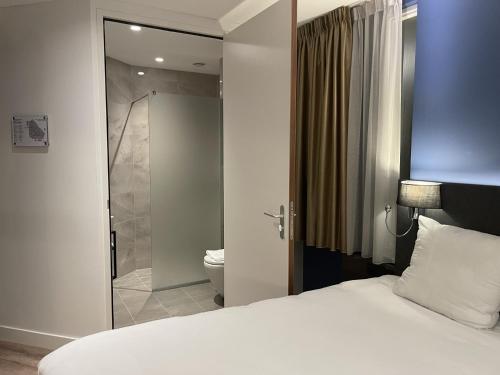 霍夫多普OZO Hotels Antares Airport的一间卧室配有一张床,浴室设有淋浴。