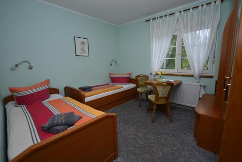 哈弗尔河畔勃兰登堡Christel's Pension的一间卧室配有一张床、一张桌子和一个窗户。