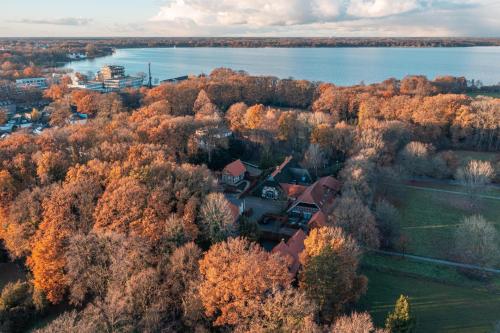 巴德茨维什安Ahrenshof Spieker W 11的湖畔森林中房屋的空中景观