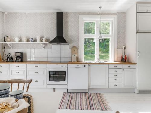 SkinnskattebergHoliday Home Idyllen - VML115 by Interhome的厨房配有白色橱柜和窗户。