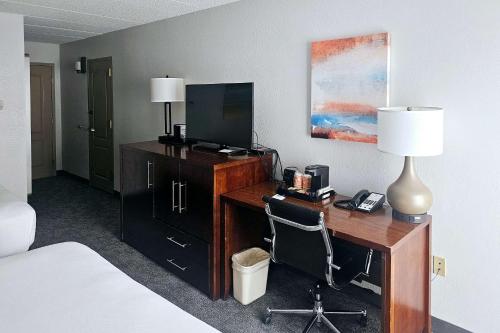 普利茅斯Comfort Inn Plymouth-Minneapolis的酒店客房配有一张书桌、一台电视和一张床