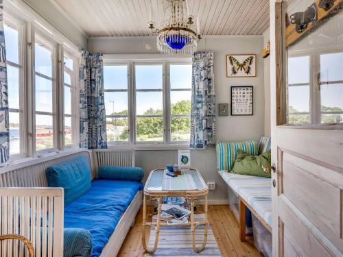 弗加尔巴卡Holiday Home Fjällbacka - BOH031 by Interhome的客厅设有蓝色的沙发和窗户。