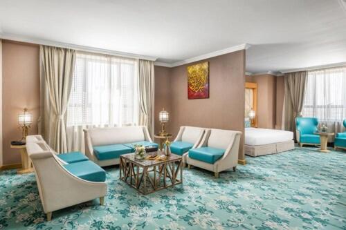 麦地那Elaf Al Taqwa Hotel的一间客厅,客厅内配有沙发和椅子