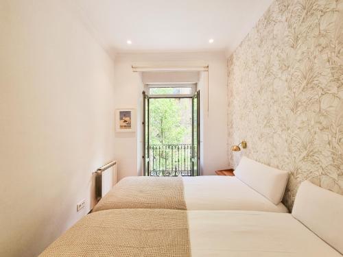 圣塞瓦斯蒂安Costa Getaria - Iberorent Apartments的一间卧室设有两张床和窗户。