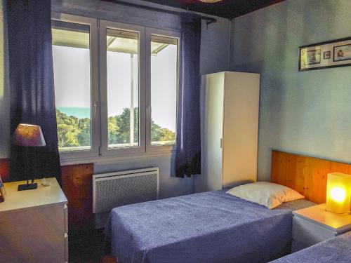 勒·雷约尔·卡纳德尔·苏尔Villa l'Escapade的一间卧室设有两张床和两个窗户。