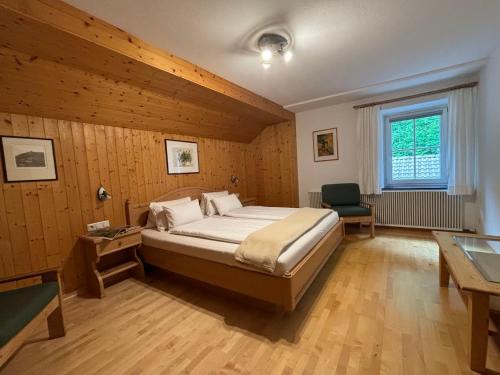 Nikolsdorf约格尔格霍夫农家乐的一间卧室配有一张床、一张书桌和一个窗户。