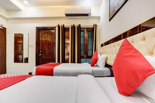 勒克瑙Super OYO Natraj Inn Near SGPGI - Managed by Company的两张位于酒店客房的床铺,配有红色枕头