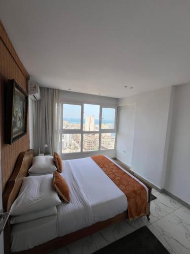 亚历山大Sea View Paradise的一间卧室设有一张大床和大窗户