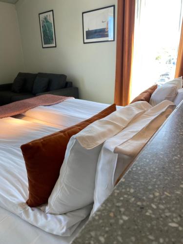 马斯特兰德马斯特兰德斯哈福斯酒店的白色的床,配有棕色和白色的枕头