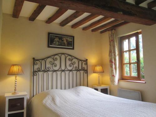 锡河边的圣奥班格内提磨坊度假屋的卧室配有白色的床和2扇窗户。